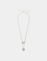Collar multicadena plateado con dije de corazón calado y dije de cuentas cilíndricas.