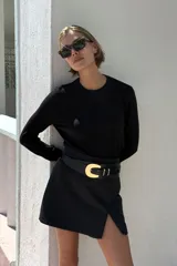 Falda pantalón negra de tiro alto con abertura frontal y cierre lateral con cremallera oculta.