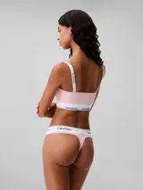Conjunto de ropa interior Calvin Klein, compuesto por un corpiño bandeau y una bombacha colaless, ambos en color rosa claro con banda elástica blanca con el logo de la marca.