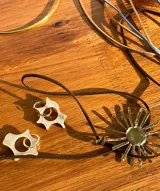 Aros colgantes de acero plateado con dijes irregulares de nácar.