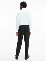 Camisa blanca de poplin con corte relaxed, mangas largas, cierre frontal con botones y bolsillo con solapa.