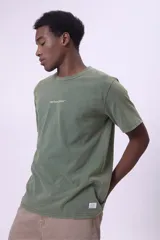 Remera gris oscuro con efecto lavado, cuello redondo y logo pequeño bordado en el pecho.