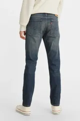 Pantalón de jean azul oscuro, de corte skinny, con tiro medio y ajuste ceñido en muslos y piernas.