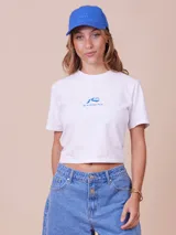 Remera cropped blanca con estampado azul, confeccionada en mezcla de algodón y elastano.