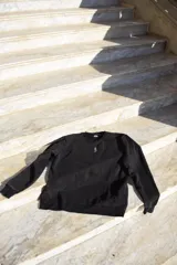 Buzo negro de algodón con efecto lavado y logo bordado en el pecho.