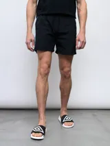 Short de baño negro con una franja vertical celeste con diseño estampado en el lateral.