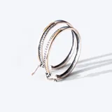 Aros en plata 925 con detalles en oro y circonias, con un diseño elegante y diámetro de 4 cm.