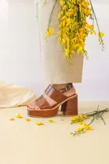 Sandalias de plataforma color marrón con textura símil piel de cocodrilo, con tres tiras anchas sobre el empeine, hebilla lateral y tacón ancho.