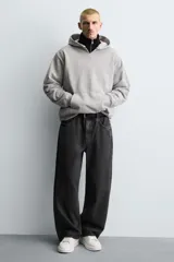 Zapatillas deportivas negras con detalle en blanco en el talón y suela blanca con volumen.