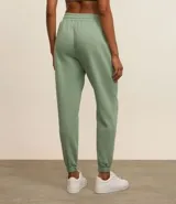Pantalón deportivo color morado, de algodón y poliéster, con cintura elástica y bolsillos laterales.