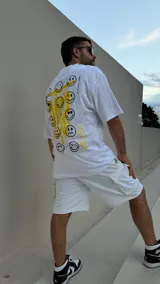 Remera blanca de algodón con estampado en serigrafía de caritas sonrientes amarillas.