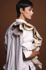 Camisa beige de algodón con cuello mao y volado estructurado.