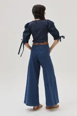 Top azul de tejido de punto con cuello cuadrado y mangas abullonadas con lazos.