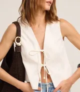 Chaleco blanco sin mangas con lazo delantero.