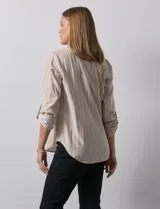 Blusa beige con rayas verticales blancas, escote en V y mangas 3/4 regulables con presilla y botón.