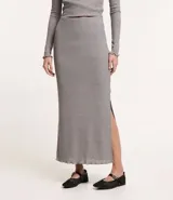 Pollera midi gris de rib acanalada con hilo metalizado, cintura elástica, abertura lateral y bajo ondulado.