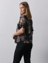 Blusa de gasa estampada con cuello a la base y escote en V. Tiene mangas cortas amplias con sobrecapas.