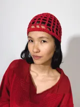 Gorro tipo casquete rojo tejido al crochet con diseño calado.