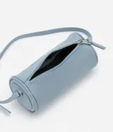 Bolso baguette pequeño cilíndrico color celeste, confeccionado en material sintético PU, con correa fina de hombro y cierre por cremallera.