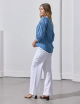 Blusa celeste de lyocell con cuello a la base y escote en V con apertura central y botones. Manga ¾ con puño y botón.