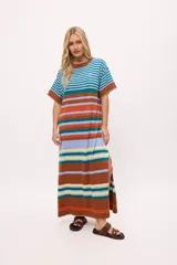 Vestido largo tejido a rayas horizontales en tonos beige, marrón, negro y rojo. Tiene cuello redondo, mangas cortas y tajos laterales.