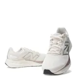 Championes New Balance 680 V8 para mujer, color beige con detalles en plateado y negro. Capellada de mesh técnico transpirable con refuerzos, entresuela Fresh Foam y suela de goma.