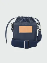Bolso bandolera verde oscuro de cuero con correa ancha ajustable y cierre con solapa y cordón ajustable.