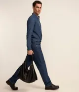 Camisa de hombre de tejido plano de algodón, color celeste claro, con cuello solapa, manga larga y bolsillo simple en el pecho izquierdo.