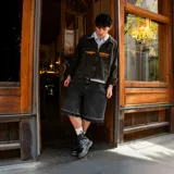 Bermuda de jean negro con corte holgado y terminaciones desflecadas.