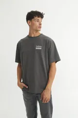 Remera color crudo de algodón, corte oversize, con estampa en el frente con la palabra 'Uniform' y un diseño rectangular debajo.