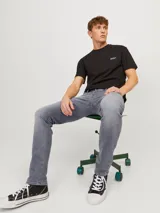 Jean de hombre gris con corte slim fit, cinco bolsillos y cierre con botón.