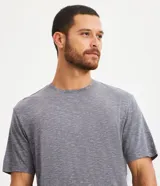 Conjunto de pijama corto para hombre, compuesto por una remera de manga corta con cuello redondo y un short con cintura elástica y cordón de ajuste. El tejido es malla flameada con efecto mezcla en tono verde claro.