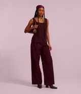 Pantalón pantalona color borgoña de tiro alto y corte palazzo, confeccionado en cupro con pliegues delanteros.