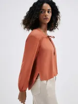 Blusa color marrón con escote en V y mangas largas.