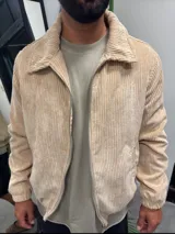 Campera color beige de pana con cierre frontal, cuello camisero y bolsillos laterales.
