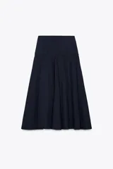 Falda midi de tiro alto color azul marino, con cintura tipo fajín y cierre lateral con botones metálicos labrados.
