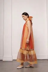 Vestido largo y amplio con cuello alto y mangas cortas abullonadas. Diseño a rayas verticales en tonos dorado y gris. Incluye viso liso al tono.