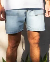 Bermuda de jean celeste con dos bolsillos frontales tipo parche, costuras a contratono y botones de cobre.