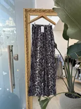 Pantalón largo de tela suave con estampado animal print, cintura elástica y bolsillos frontales.