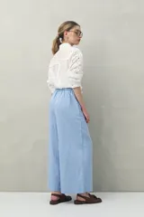 Pantalón palazzo color crema, de tiro medio con cintura elastizada en la parte posterior. Confeccionado en mezcla de lino y viscosa.