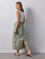 Falda larga color beige, de corte recto, con bolsillos cargo laterales y traseros, pretina con pasadores, botón y cierre.