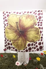 Pañuelo cuadrado de poliéster con estampado de lunares marrones sobre fondo blanco y una gran flor amarilla con detalles en bordó en el centro.