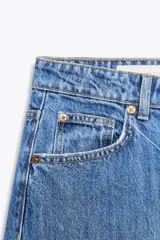 Pantalón de jean celeste de corte amplio, tiro medio, con cinco bolsillos y detalle de costuras torcidas.