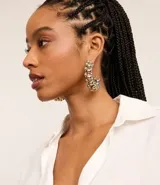 Aros de metal dorados con forma de aro grueso, decorados con esferas de diferentes tamaños en tonos dorados y plateados.