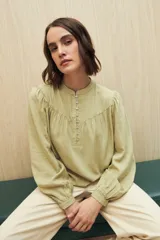 Camisa celeste de manga larga en viscosa suave, con cuello mao y botonadura parcial al frente. El detalle de frunces en los hombros y los puños abotonados le suman delicadeza y estilo.