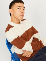 Polo de manga larga tejido jacquard con rayas horizontales color marrón y crudo, cierre de medio botón y fit relajado. Confeccionado con 50% algodón y 50% poliéster reciclado.