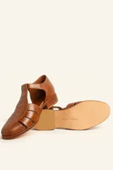 Sandalia marrón de cuero vacuno con diseño de tiras entrecruzadas, hebilla lateral y taco bajo de 2,5 cm.