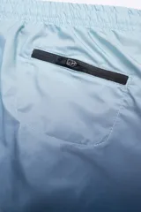 Short de baño con degradé de celeste a azul marino, con cintura elástica ajustable, dos bolsillos laterales y uno trasero con cierre. Cuenta con suspensor de malla fina hipoalergénico y protección UV 50.