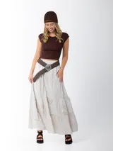 Cinto marrón trenzado con hebilla circular plateada con piedra marrón al centro.