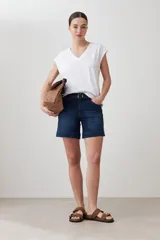 Remera blanca de corte recto, con escote en V y mangas cortas. Presenta detalle de abertura en la espalda.